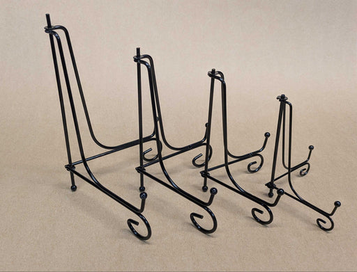 Four black metal display stands of varying heights arranged in a row to illustrate height