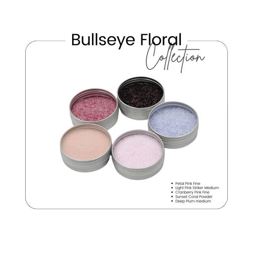 An image displaying five small round tins of Bullseye glass frits in various colors including pinks and purple, labeled as the Bullseye Floral Collection.